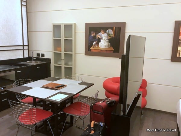 A giant TV divides the kitchen area from the sleeping area in our apartment at Art Hotel Commercianti