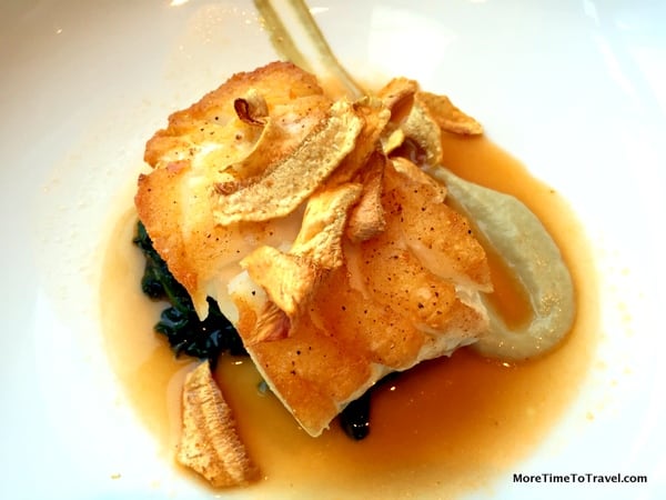 Seared black cod on a bed of baby spinach with artichokes and lobster lemongrass broth