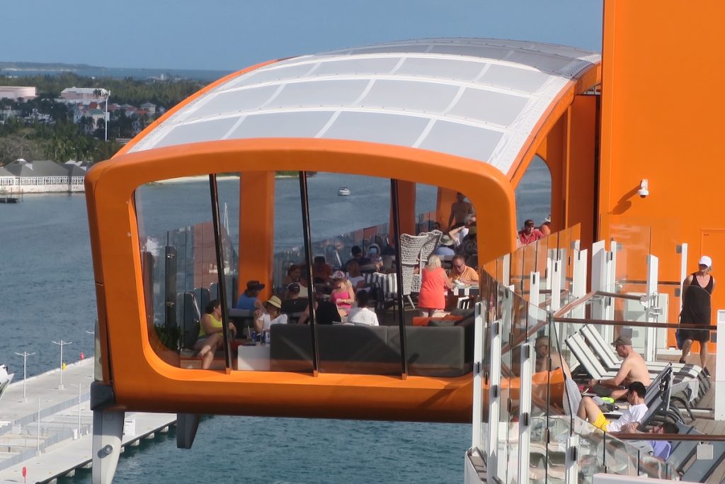 The unique Magic Carpet--a bar, restaurant and tender platform--moves vertically on the starboard side of the ship