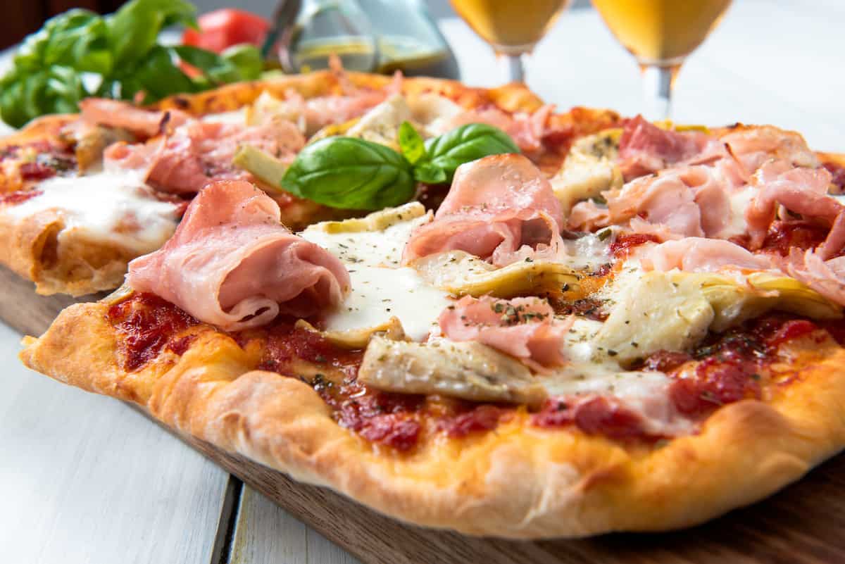 Pinsa Romanda con prosciutto, carciofi, pomodoro e mozzarella